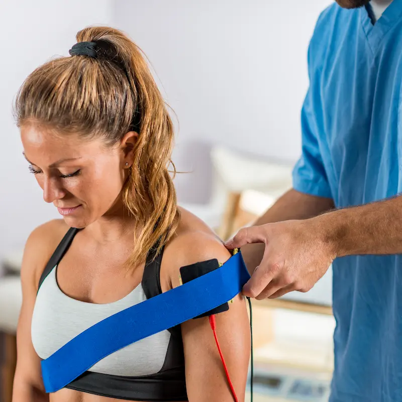 electrical-stimulation-physical-therapy-therapist-positioning-electrodes-patient-s-shoulder